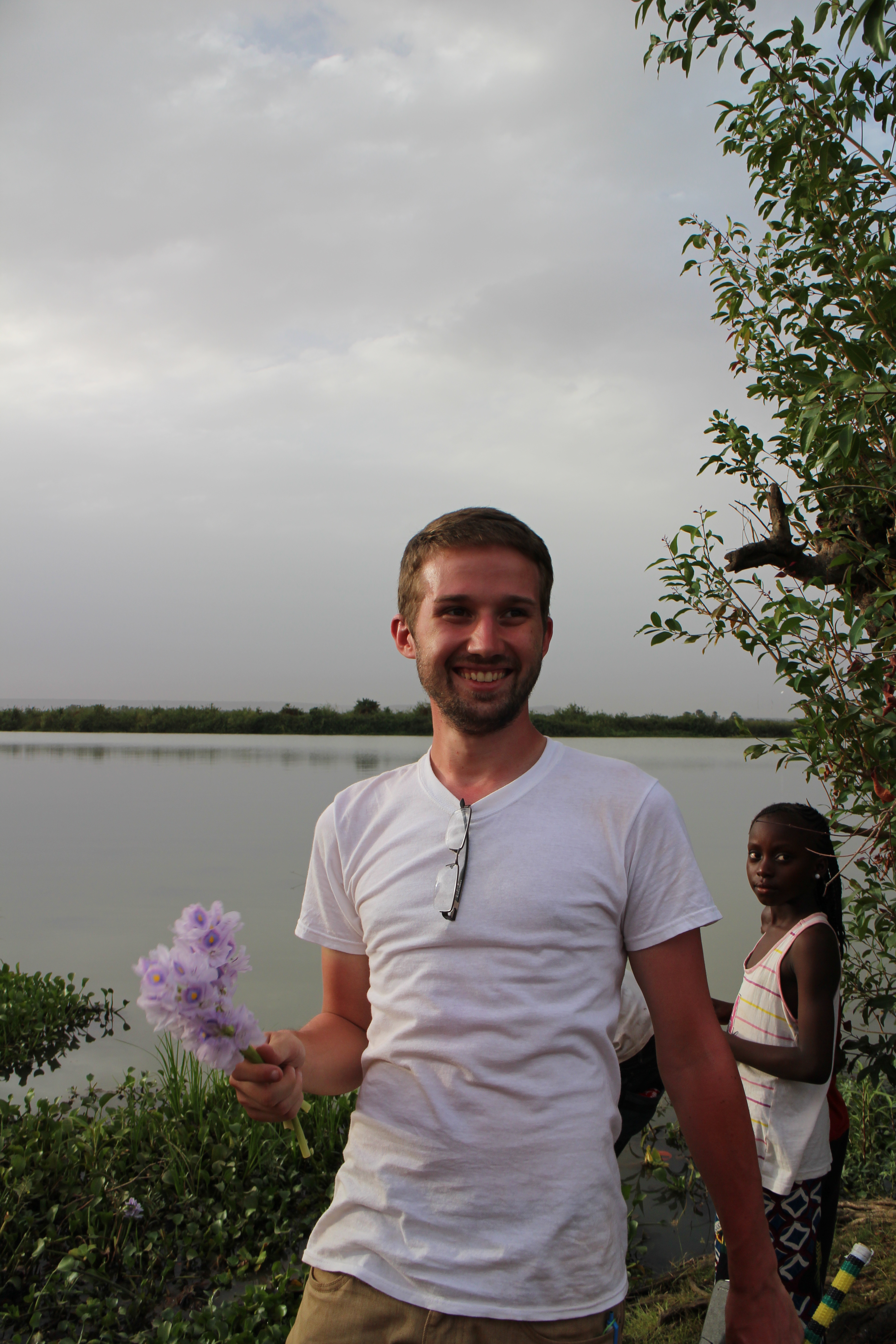 Man holding flowers near river